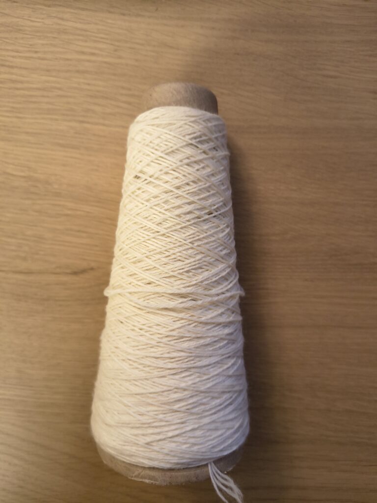 Cone end of Jagger Spun Superwash Sock Wool 14/4 NeK - Ecru